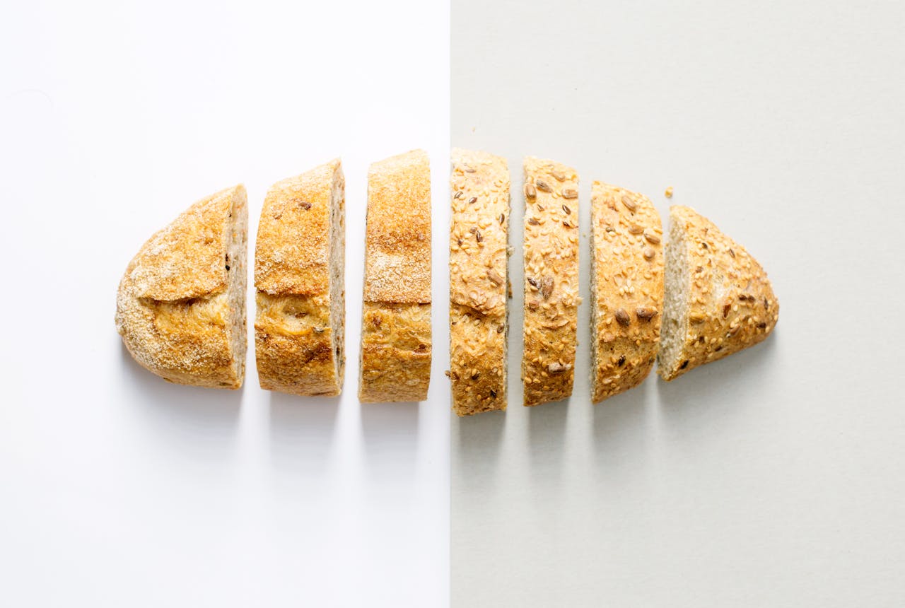 our-services-3 Freshly baked whole wheat bread sliced on a white background, showcasing its homemade texture.