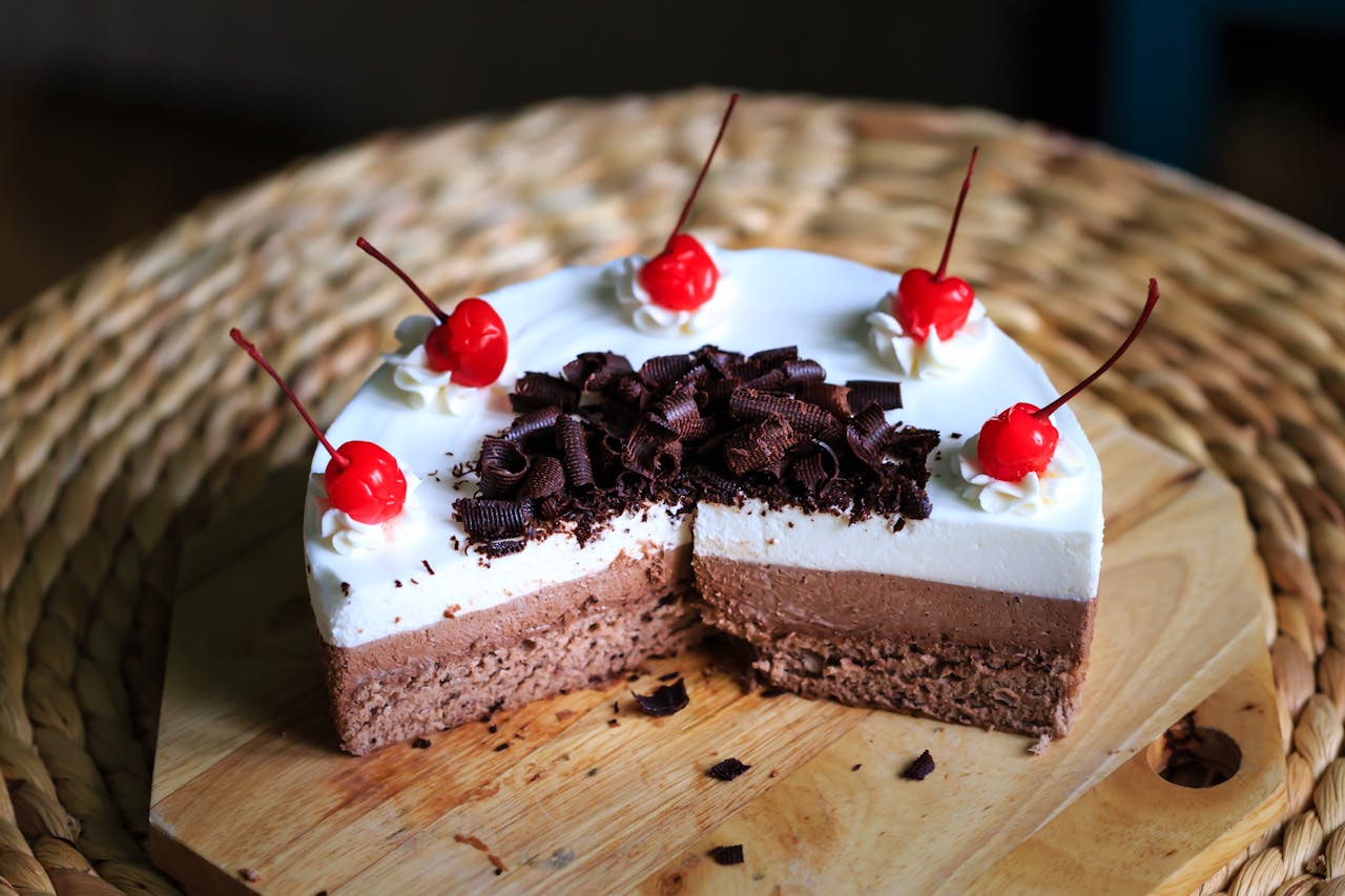 gallery-4 Delicious chocolate mousse cake topped with cream, cherries, and chocolate shavings.